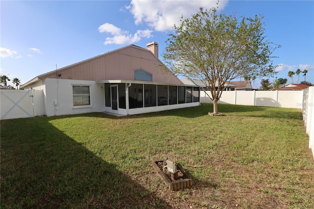 rear view of property with a sunroom and a lawn