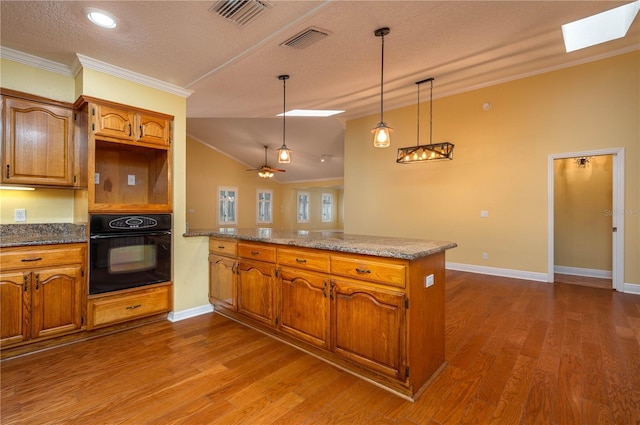 kitchen featuring kitchen peninsula, dark hardwood / wood-style flooring, black oven, ornamental molding, and decorative light fixtures