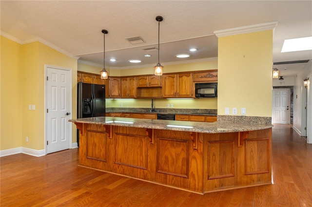 kitchen featuring kitchen peninsula, dark hardwood / wood-style floors, black appliances, and a textured ceiling