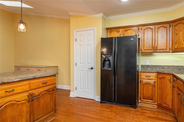 kitchen featuring light wood-type flooring, black refrigerator with ice dispenser, pendant lighting, light stone counters, and ornamental molding