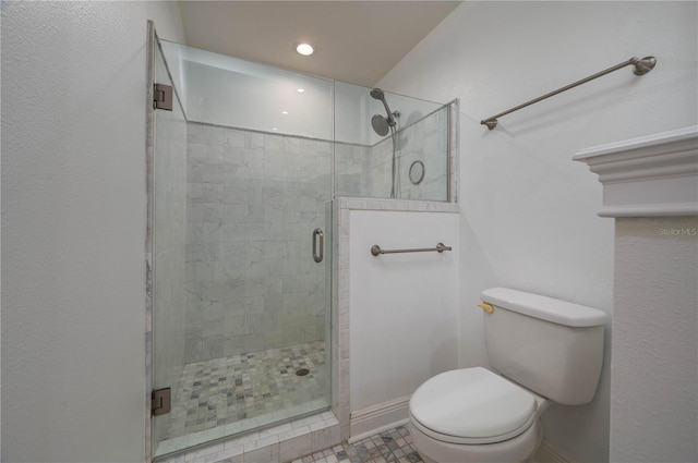 bathroom featuring tile patterned floors, a shower with shower door, and toilet