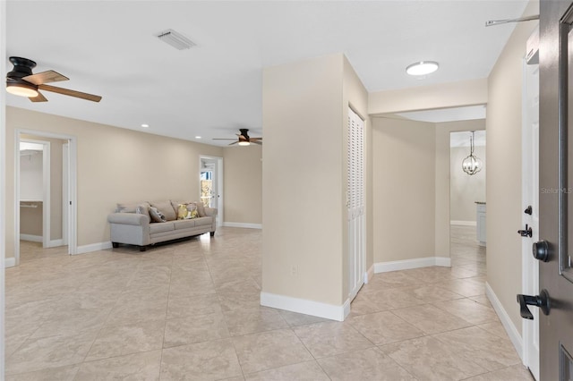 hallway with a notable chandelier and light tile patterned floors