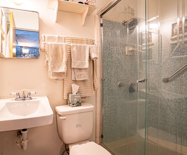 bathroom with toilet and a shower with shower door