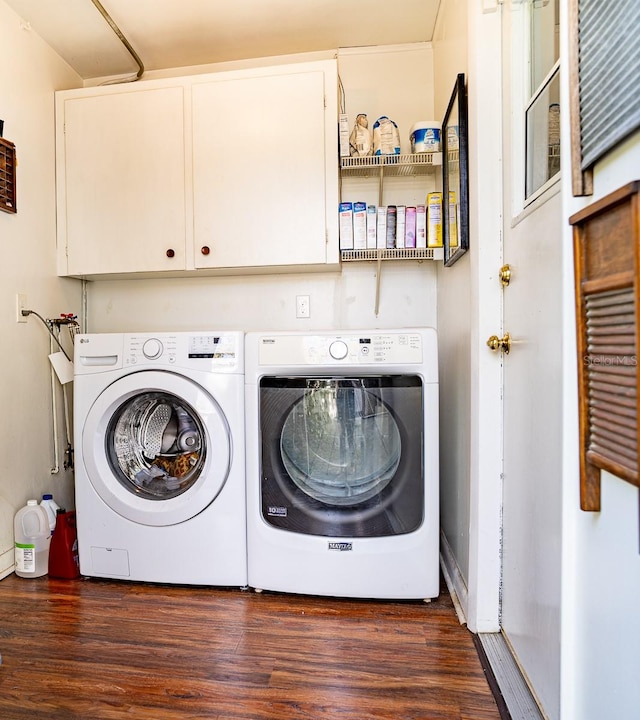 laundry area with washer and dryer, dark hardwood / wood-style floors, and cabinets