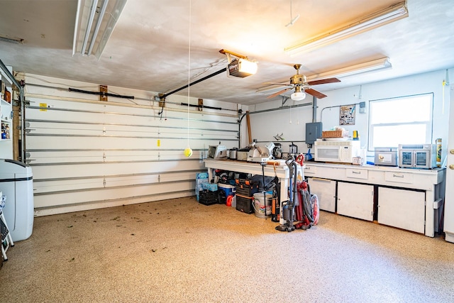 garage featuring a garage door opener, electric panel, and ceiling fan