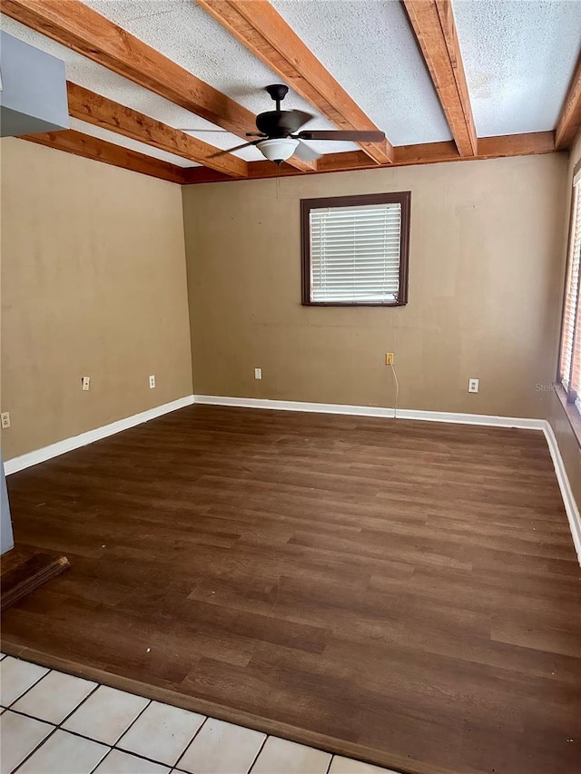 spare room with beam ceiling, hardwood / wood-style flooring, a textured ceiling, and ceiling fan