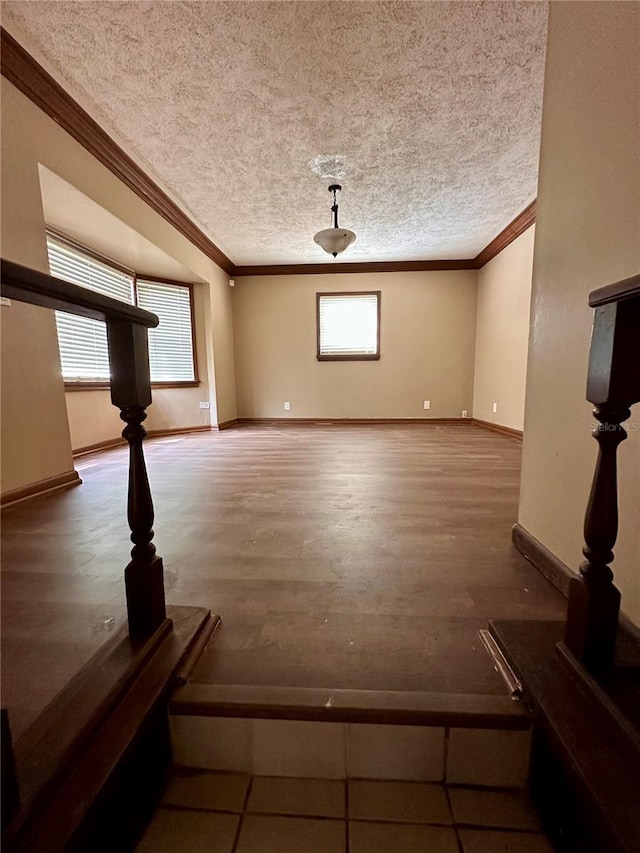 unfurnished living room featuring ornamental molding, a textured ceiling, and hardwood / wood-style flooring