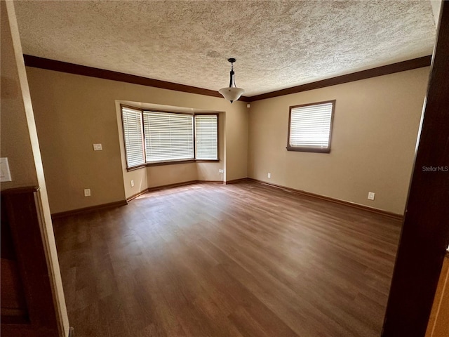 unfurnished room with crown molding, hardwood / wood-style flooring, a textured ceiling, and plenty of natural light