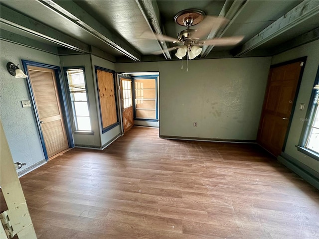 spare room with beam ceiling, a baseboard radiator, light wood-type flooring, and ceiling fan