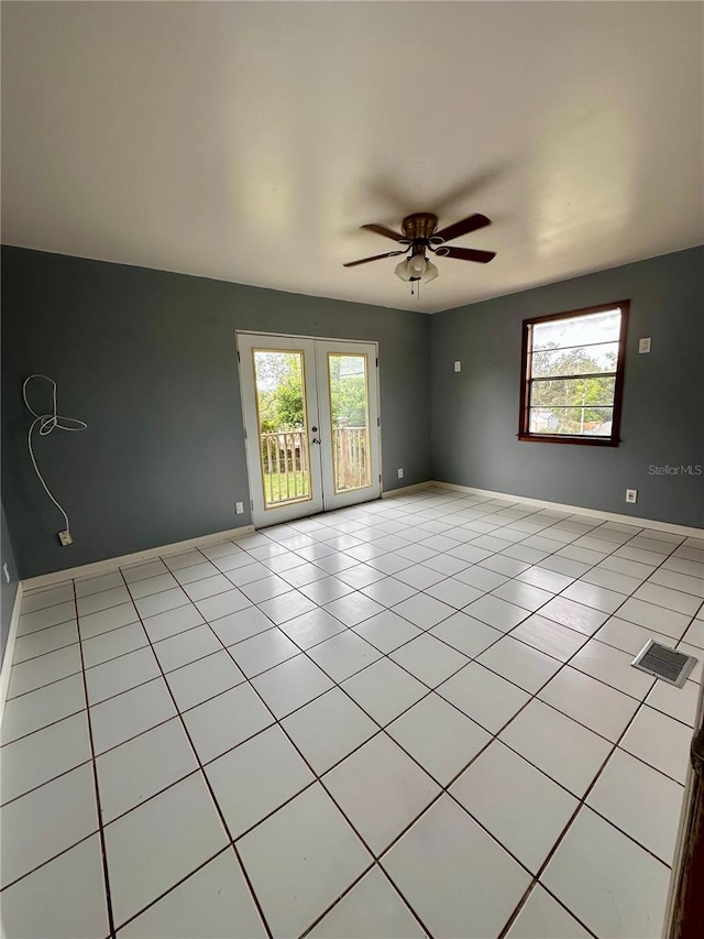 tiled empty room with french doors and ceiling fan