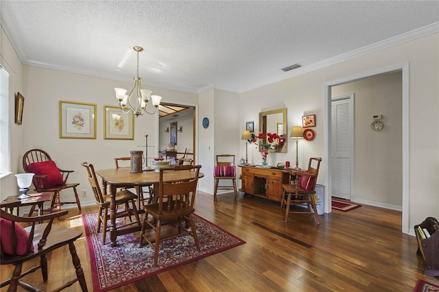 dining room with ornamental molding, a textured ceiling, an inviting chandelier, and dark hardwood / wood-style flooring