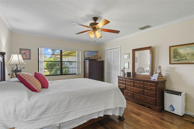 bedroom featuring dark hardwood / wood-style flooring, ceiling fan, a textured ceiling, ornamental molding, and a closet