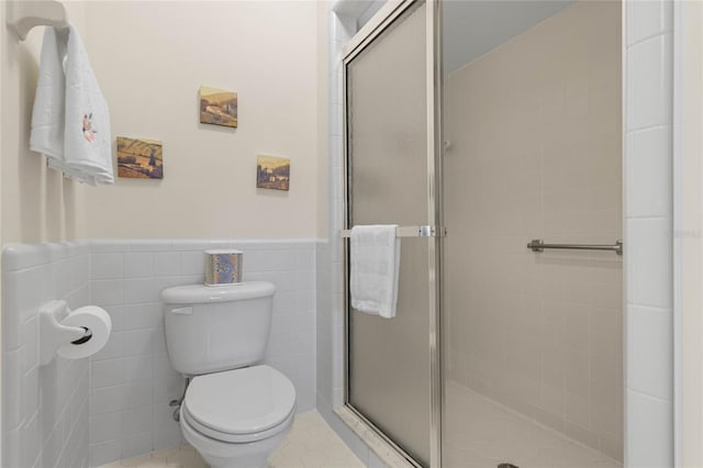 bathroom with toilet, an enclosed shower, and tile walls