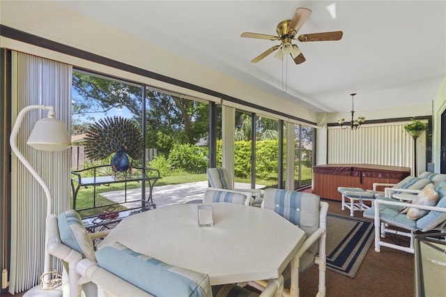 sunroom featuring ceiling fan with notable chandelier and a jacuzzi