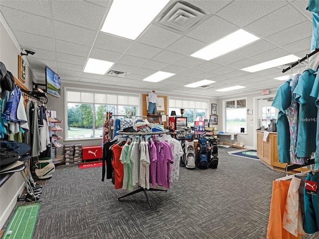 miscellaneous room featuring a drop ceiling and dark colored carpet