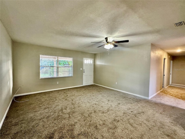 carpeted spare room featuring a textured ceiling and ceiling fan