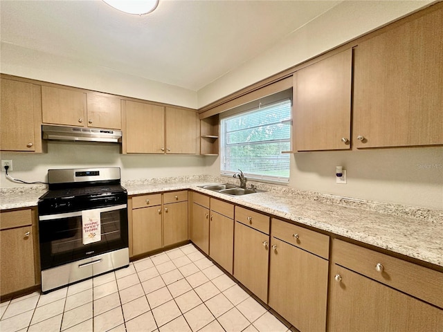 kitchen with light brown cabinets, light tile patterned floors, light stone countertops, stainless steel range oven, and sink