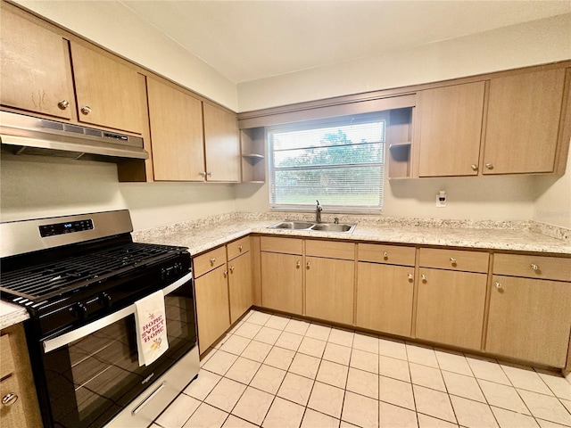 kitchen with stainless steel range, light brown cabinets, sink, and light tile patterned floors