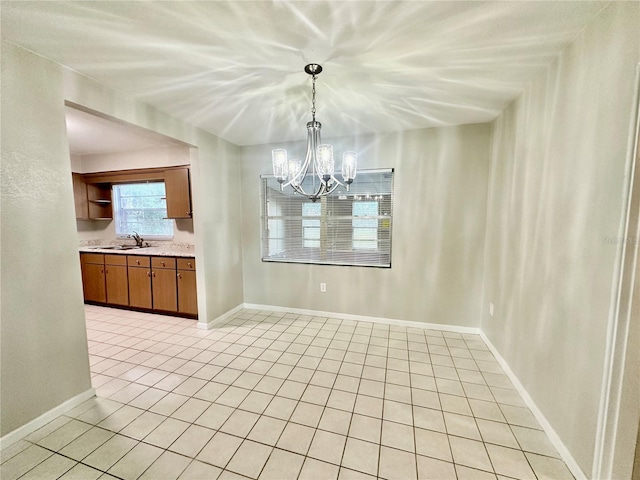 unfurnished dining area featuring sink, light tile patterned floors, and an inviting chandelier