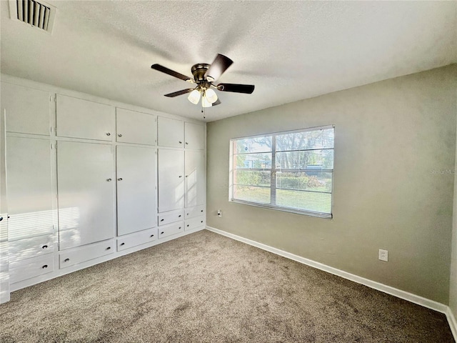 unfurnished bedroom featuring carpet floors, a textured ceiling, and ceiling fan