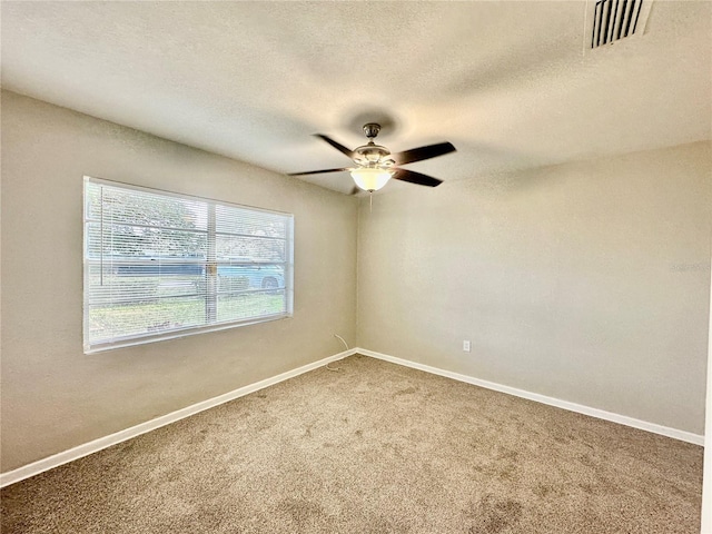 empty room with a textured ceiling, carpet floors, and ceiling fan