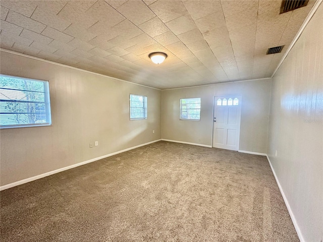 unfurnished room with ornamental molding and carpet floors