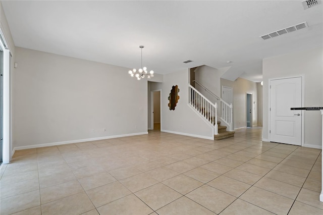 tiled spare room with a notable chandelier