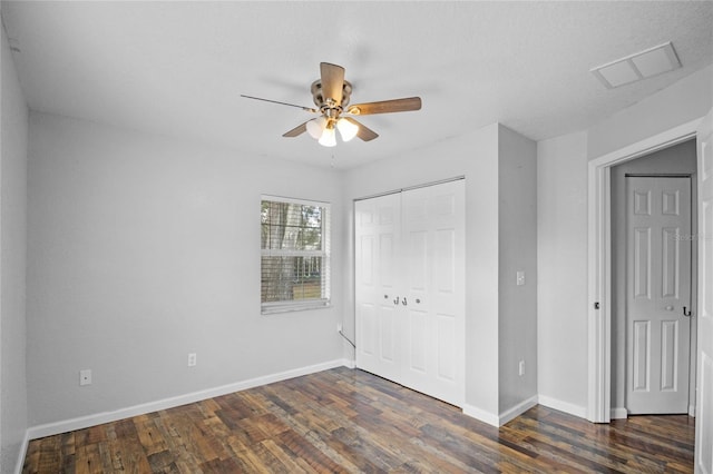 unfurnished bedroom featuring dark wood-type flooring, ceiling fan, and a closet