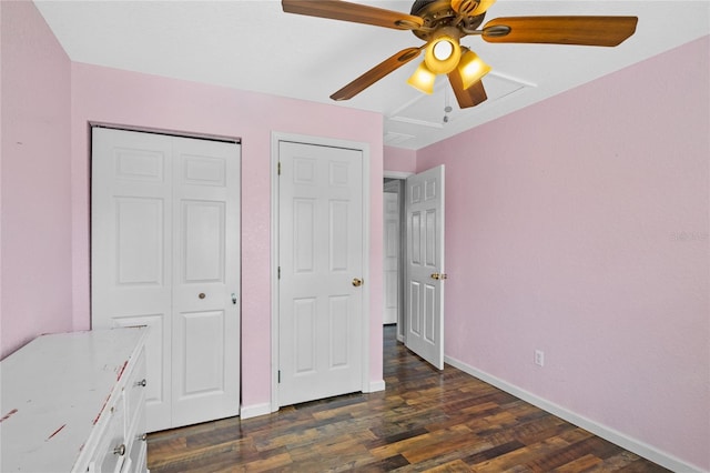 unfurnished bedroom with dark wood-type flooring, ceiling fan, and a closet