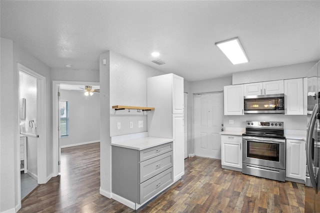 kitchen featuring white cabinetry, appliances with stainless steel finishes, dark hardwood / wood-style floors, and ceiling fan