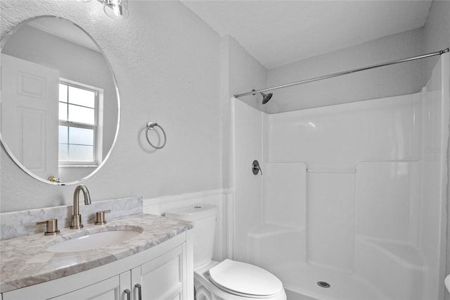 bathroom featuring vanity, toilet, and a shower