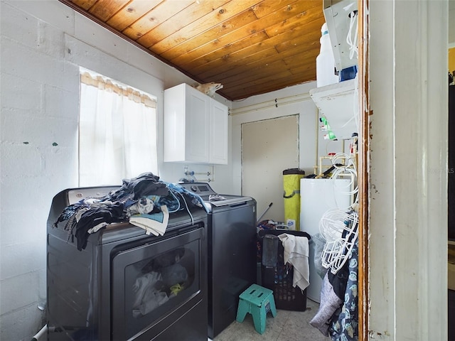 laundry area with wooden ceiling, gas water heater, separate washer and dryer, and cabinets