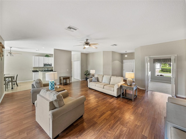 living room featuring wood-type flooring and ceiling fan