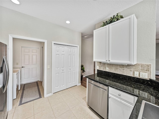 kitchen with tasteful backsplash, dark stone counters, white cabinetry, appliances with stainless steel finishes, and light tile patterned floors