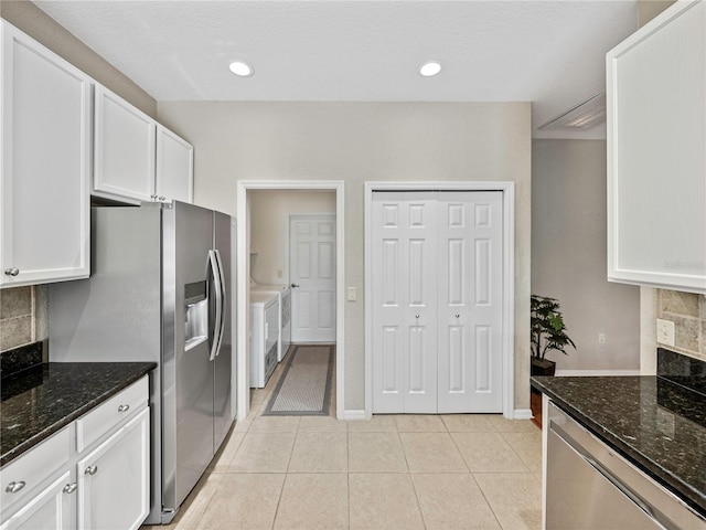 kitchen with dark stone countertops, white cabinetry, and decorative backsplash