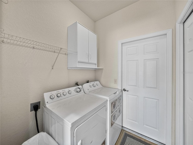 clothes washing area with cabinets and washer and dryer