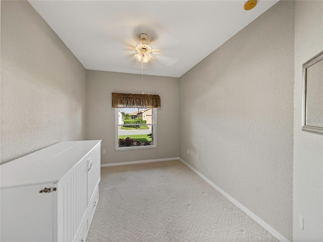 carpeted spare room with ceiling fan