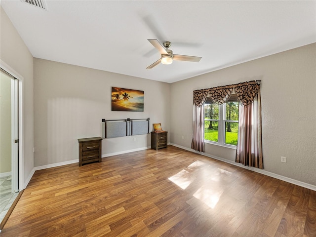 unfurnished living room featuring wood-type flooring and ceiling fan