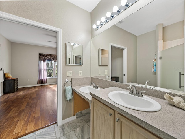 bathroom featuring hardwood / wood-style flooring, a shower with door, and vanity