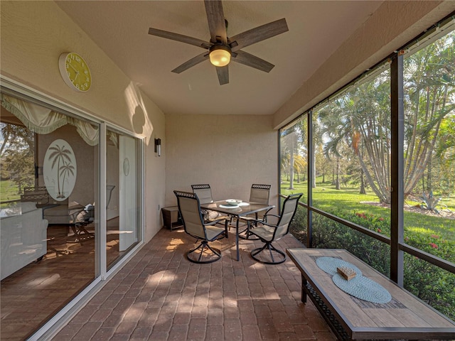 unfurnished sunroom with ceiling fan