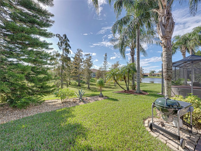 view of yard with a water view and a lanai