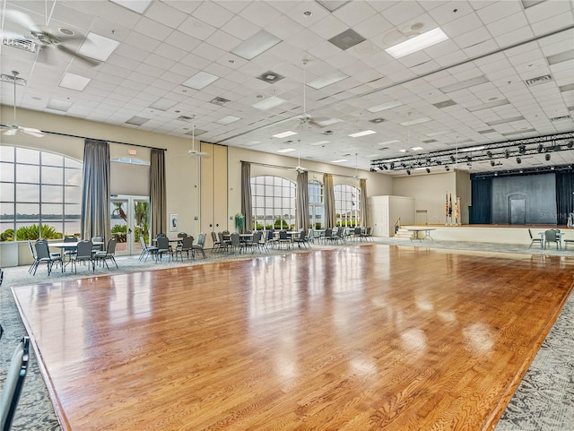 gym with a drop ceiling, light hardwood / wood-style flooring, and ceiling fan