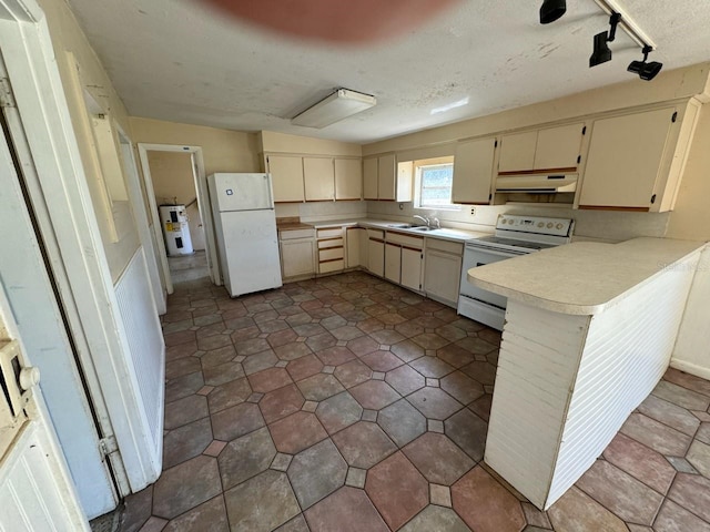 kitchen with cream cabinetry, water heater, kitchen peninsula, sink, and white appliances