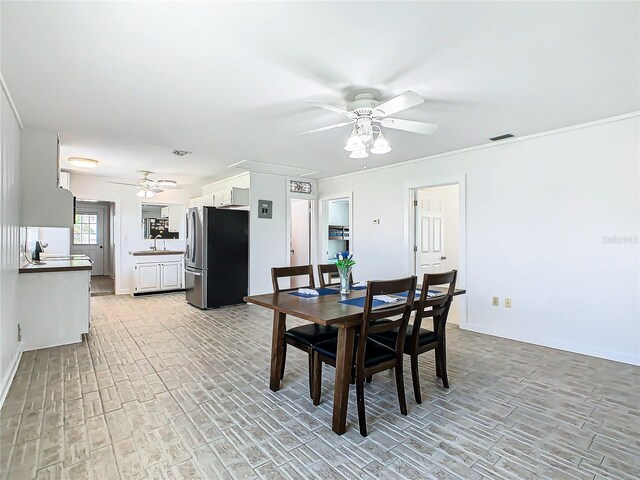 dining area featuring light hardwood / wood-style floors, sink, and ceiling fan