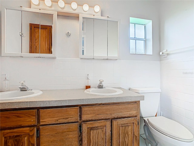 bathroom featuring vanity, toilet, and tile walls