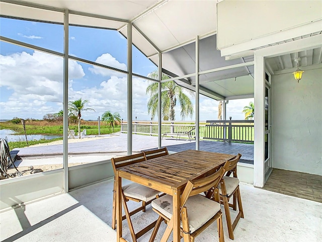 sunroom / solarium featuring a water view