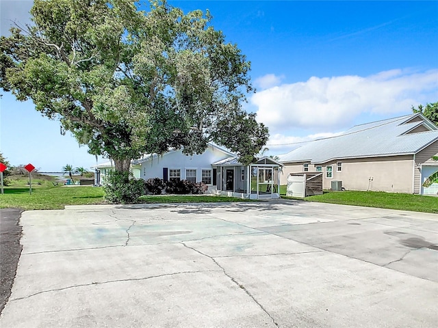 single story home featuring cooling unit and a front lawn