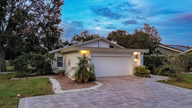 single story home featuring a front lawn and a garage