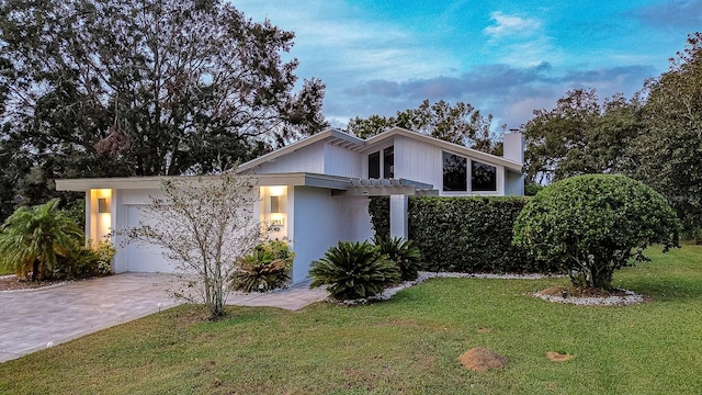 view of front of home featuring a front lawn, a garage, and a pergola