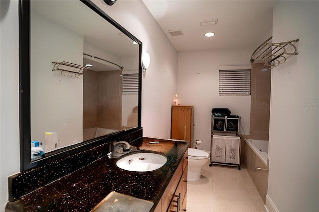 bathroom with a bathing tub, vanity, tile patterned floors, and toilet